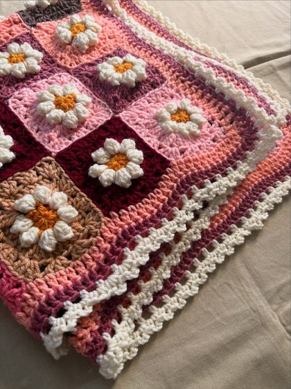 This detailed shot shows the corner of the Daisy blanket, focusing on the multiple layers of the border and the texture of the granny squares. Every stitch is made with care to ensure the blanket is durable and will last for generations.