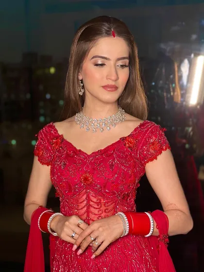Bold, beautiful, and breathtaking in red for her reception. This new bride redefines tradition with a modern glam twist, featuring sleek hair and flawless makeup.