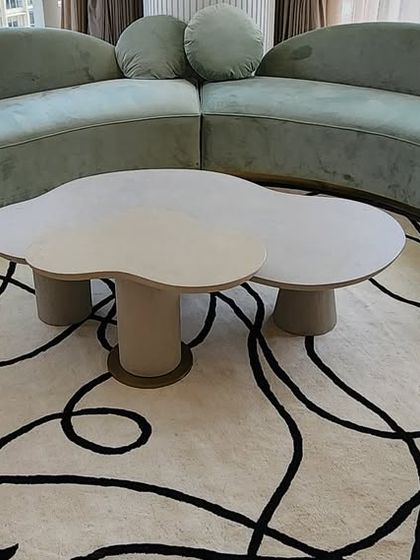 And here is the final product. The custom-designed, cloud-shaped center table sits perfectly on a modern rug, complementing the curved sofa and creating a soft, sculptural centerpiece for the living room.