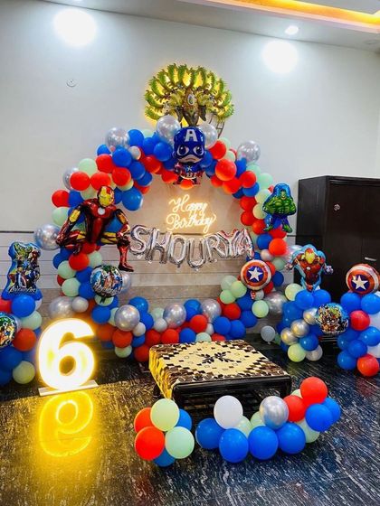 An action-packed Avengers superhero theme for a 6th birthday, with character balloons like Iron Man and Captain America, and a glowing number sign.