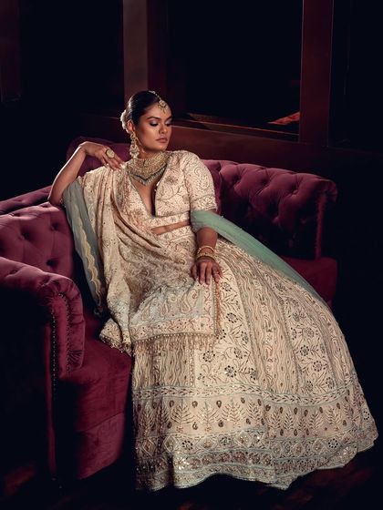 A dramatic, low-light bridal portrait using a chandelier to create a luxurious and moody atmosphere. This style is perfect for designers wanting to showcase their collection with a touch of opulence and drama.