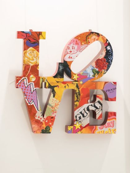 "Love Unleashed" reinterprets Robert Indiana’s iconic LOVE sculpture. Layered with a vibrant pop art collage, it transforms the classic form into a celebration of contemporary culture and creativity.