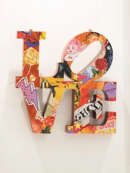 "Love Unleashed" reinterprets Robert Indiana’s iconic LOVE sculpture. Layered with a vibrant pop art collage, it transforms the classic form into a celebration of contemporary culture and creativity.