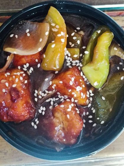 A single serving of my Chilli Paneer, with chunks of paneer, capsicum, and onion in a flavorful sauce.