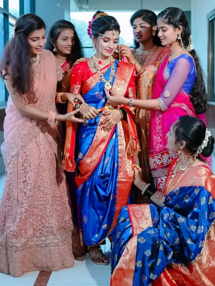 The bride surrounded by her bridesmaids, who help her with the final touches. A beautiful moment of friendship and support on the big day.