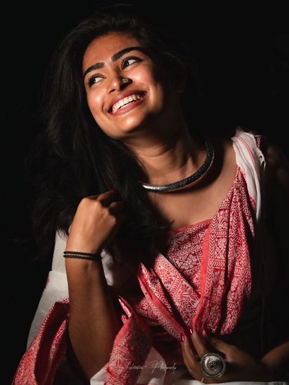 A joyful, candid-style studio shot. The lighting highlights the cheekbones and the smile, and the makeup enhances this natural expression of happiness.