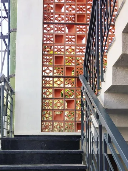 A close-up of a terracotta jali screen on a staircase wall. This detail showcases my commitment to using traditional, sustainable materials like clay blocks to create functional art that provides ventilation and visual interest.