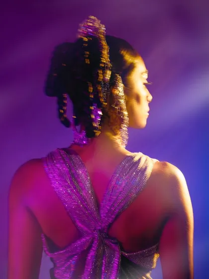 A shot focusing on the back of the garment and the intricate, sparkling hairstyle. This image highlights the details that complete the overall conceptual look.