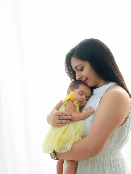 A tender moment as a mother holds her sleeping baby close to her heart. The image radiates warmth, comfort, and the pure love of motherhood.