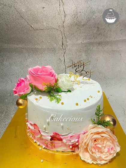A simple cake with a touch of floral magic. This design uses a mix of fresh and artificial flowers in shades of pink, perfect for a birthday or anniversary.
