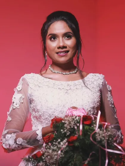 A beautiful bride holding her bouquet at her Christian wedding. Her makeup is soft and romantic, with a focus on her eyes.