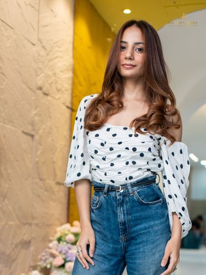 A full-length view of the client, her new balayage complementing her style and boosting her confidence.