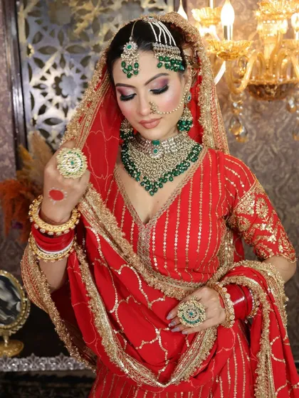 A closer look at the red gota patti lehenga and the layered emerald jewelry set.