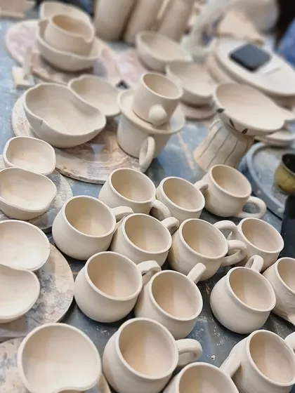 A random shot from the studio, showing dozens of mugs and bowls in their pre-fired 'greenware' state. This is just one stage in the long journey each piece takes before it's finished.