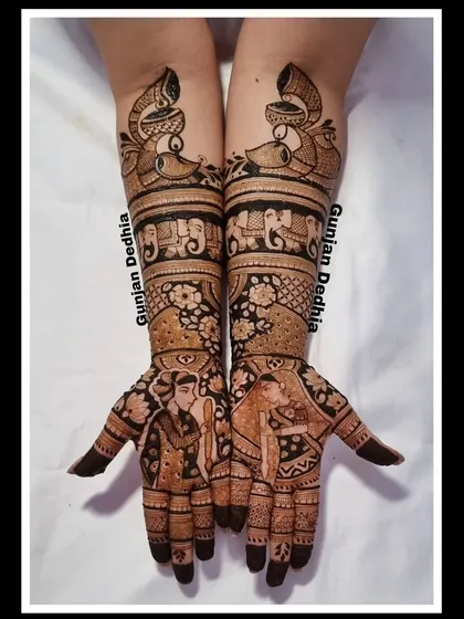 A classic bridal design featuring bride and groom portraits. The intricate patterns and traditional motifs like peacocks and elephants complete the look.