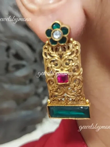 A client showcasing the elegant Dakshinaya temple-style earrings. The rectangular shape and intricate gold work are characteristic of South Indian jewellery, offering a look of grace and tradition.
