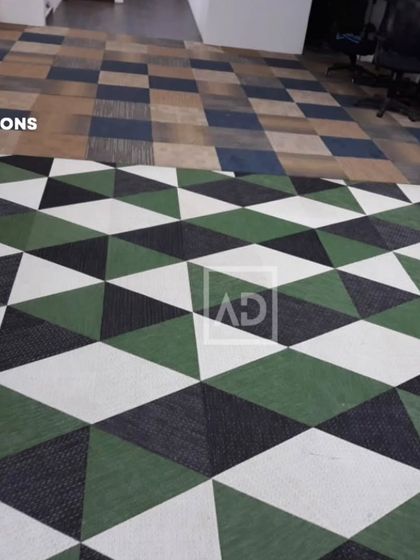 This image shows two different carpet tile designs in an office. The geometric pattern in the foreground and the checkered pattern in the background demonstrate how tiles can be mixed to define different zones.