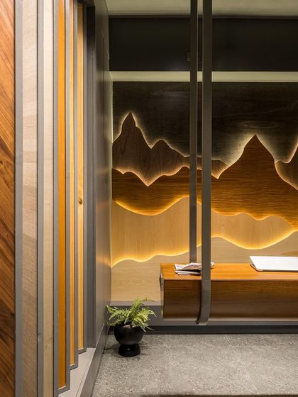 A custom-designed swing bench, suspended from the ceiling, sits before a backlit veneer wall art piece. This feature creates a memorable and interactive moment within the showroom.