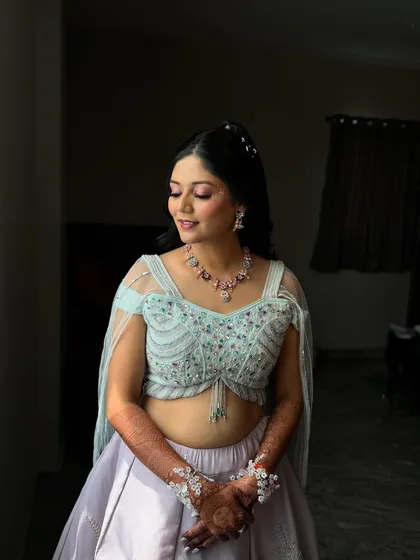 Bathed in sunlight, our bride for the Haldi carnival looks serene and beautiful. The makeup is soft and romantic, with a touch of pink on the eyes and lips.