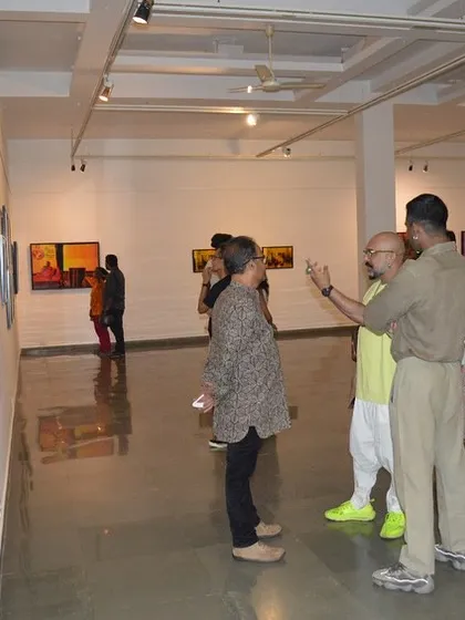 Visitors discussing the works on display at Sandeep T K's exhibition.