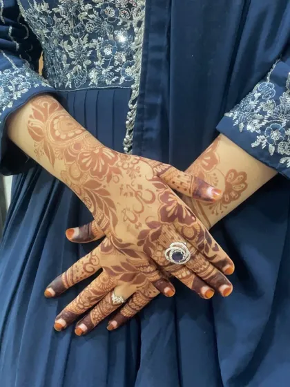 Both hands adorned with a fresh floral henna design. This pattern is perfect for an engagement or party, offering a look that is both elegant and festive.