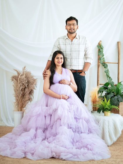 A formal couple's portrait in our bright studio setup, showcasing the full elegance of the lavender gown.