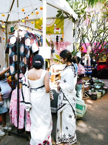Shoppers admiring handcrafted apparel at a stall. The mix of traditional and contemporary designs is a hallmark of our curated collections.