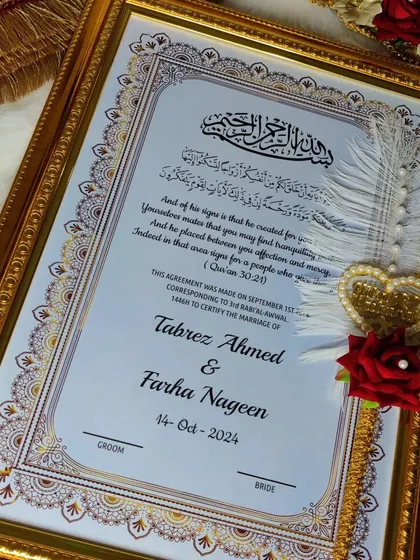 A slightly different view of the framed Nikah nama, showing the groom's signature line. The feather and pearl details on the pen add a touch of softness.