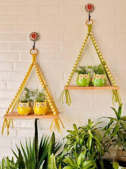 Our latest macrame and beads wall shelves are available in six vibrant colors. This image shows the mustard yellow and evergreen options, paired with our cute ceramic owl planters for a cheerful and green setup.