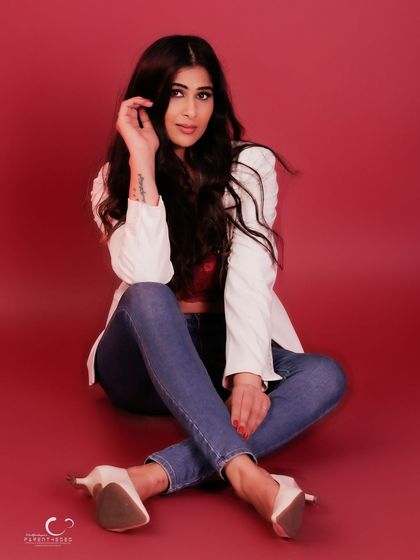 A classic cross-legged pose that feels both casual and elegant. Her direct gaze and relaxed posture make for an engaging portrait.