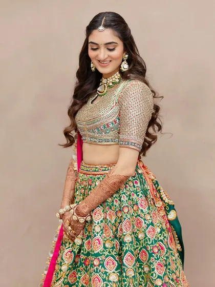For her carnival-themed event, this bride wore a beautiful green floral lehenga. The makeup is kept fresh and pretty with soft waves in her hair.