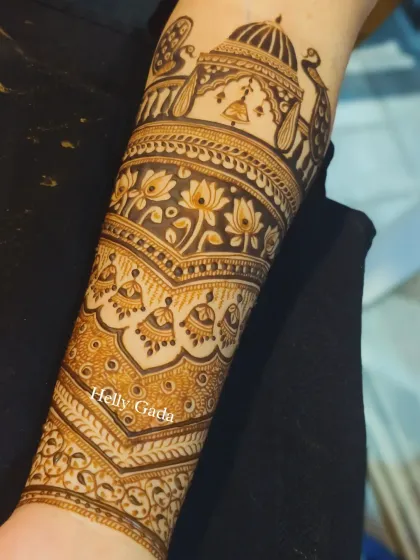 This arm band is a masterpiece of intricate details, featuring a doli, jhumkas, lotuses, and peacocks. It's a story of a wedding procession told in henna.