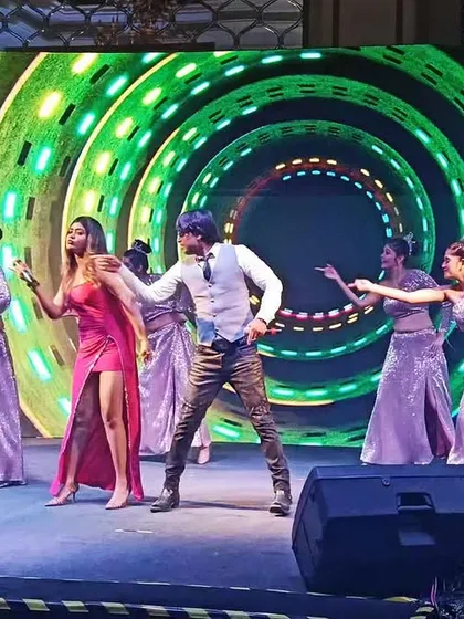 Dancing with my team against a vibrant, swirling LED background. The visual production is as important as the music.