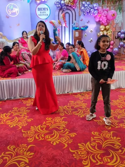 Handing out prizes to the youngest winners of a party game. I believe in making events fun for all ages, from six to sixty.