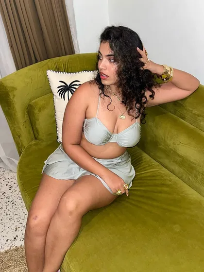 Lounging on a green velvet couch that perfectly matches my outfit's vibe. I love a good color-coordinated moment.