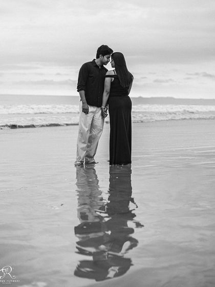 This black and white shot creates such a moody and romantic atmosphere. The reflection on the wet sand adds a beautiful symmetry to this intimate moment from a pre-wedding beach session in Goa.