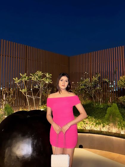 A full shot of the pink dress against a dark sky, making the color pop.