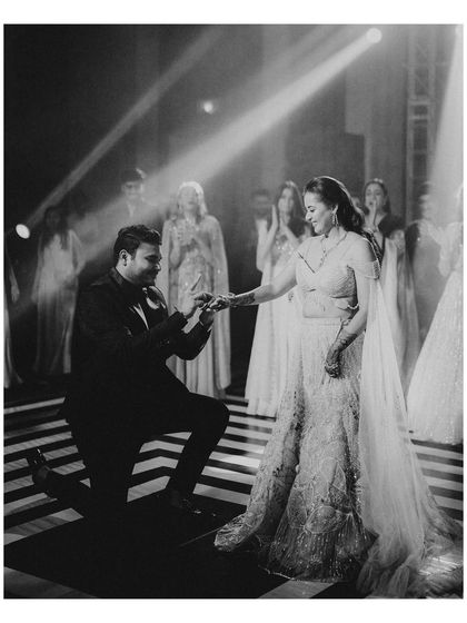 A classic proposal moment on the dance floor. The groom on one knee, the bride's happy reaction, and the friends watching in the background create a perfect story in one frame.