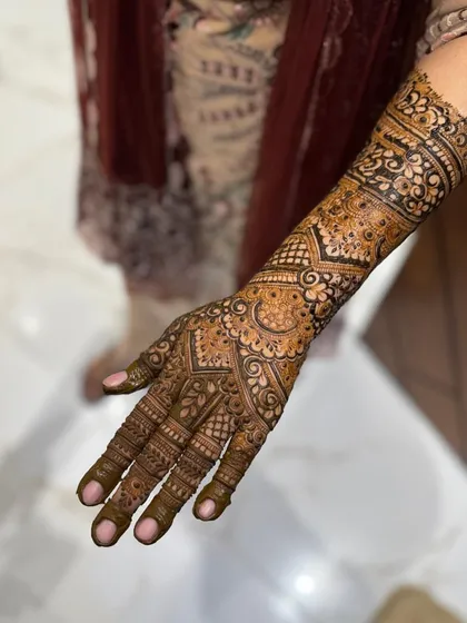 This design features a mix of geometric shapes and floral motifs, extending up the arm for a classic engagement look.