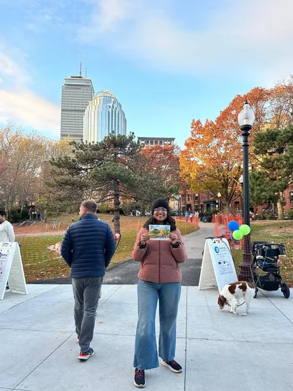 Another shot of me holding my finished watercolour painting in Titus Sparrow Park, with the Boston skyline in the background.