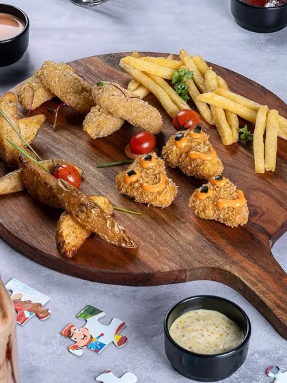 This kids' platter is designed for fun and flavor. It has a little bit of everything: potato wedges, fries, and nuggets, with dips on the side.
