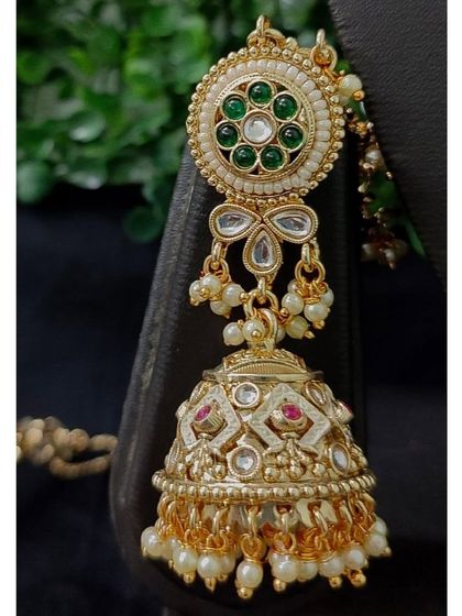 The matching jhumka earring, featuring a beautiful circular top and intricate work on the bell.