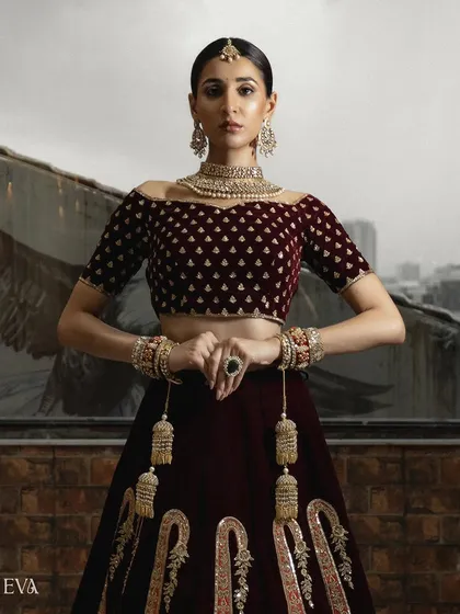 A powerful, centered shot of the model in a full bridal lehenga. The composition emphasizes the symmetry and richness of the traditional Indian bridal wear.
