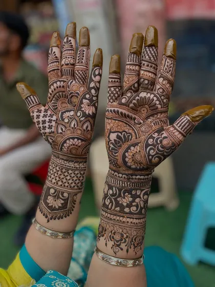 Another angle of the classic bridal design, highlighting the intricate work on the fingers and the detailed bands on the wrists.