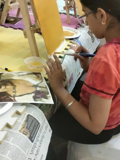 Learning from the masters! This student is studying a reference photo of an Amrita Sher-Gil painting while working on her own acrylic version, a great practice for developing observational skills.