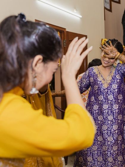 A fun, candid moment of dancing and laughter, showcasing the comfortable and vibrant Mehendi look.
