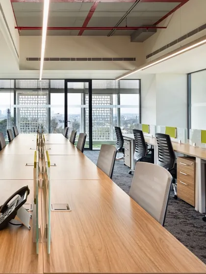 Workstations positioned along a wall of windows in a modern office. This design choice maximizes access to natural light and provides employees with expansive views, which is proven to enhance well-being and focus.