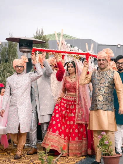 Another angle of the bride's entry, showing the brothers and family members holding the phoolon ki chadar. It’s a moment full of tradition and family love.