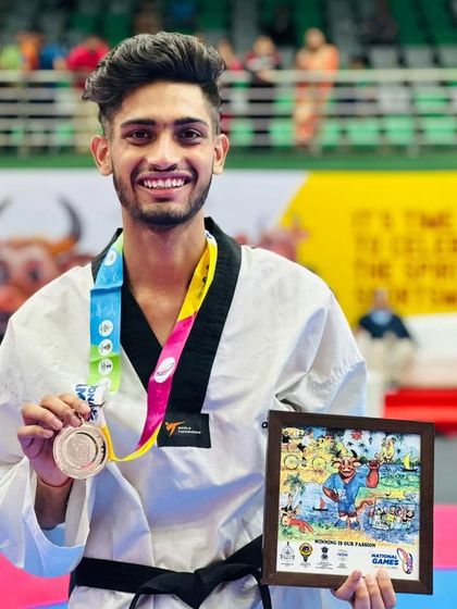 A close-up of a champion. Deepanshu proudly displaying his Bronze medal from the National Games 2023.