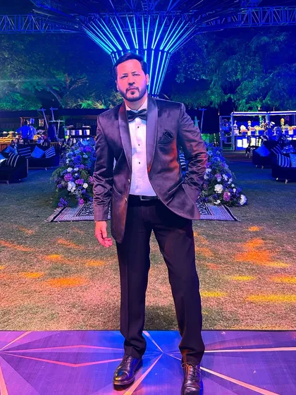 A full-length shot showcasing the formal look against a stunning event setup. I dress to impress for your special night.